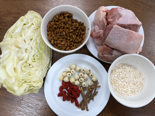 食材包含高麗菜、雞腿肉、柴胡、乾蓮子、枸杞及燕麥或飼料。圖／新北動保處